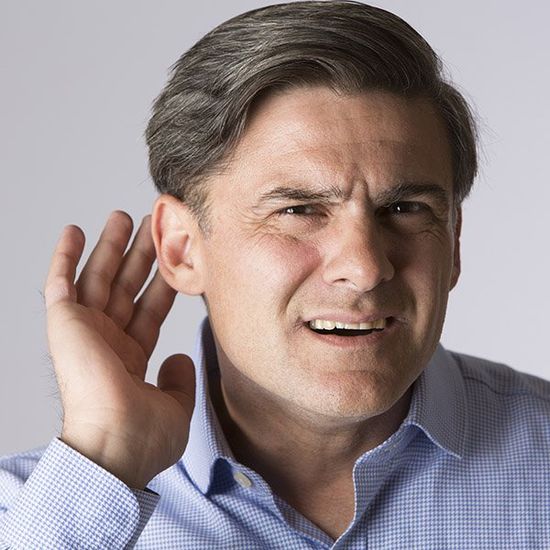 Uomo fa gesto di non sentire con la mano a coppa