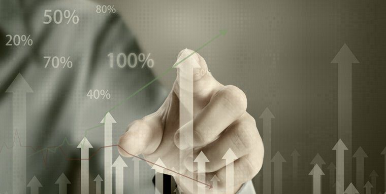 A finger pointing at arrows and percentages etched on a clear board