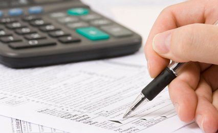 A form being signed, with a calculator nearby
