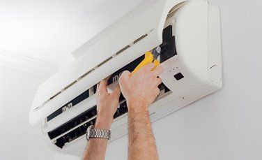 man servicing an ac unit