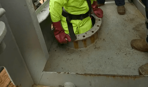 Worker climbing into tank