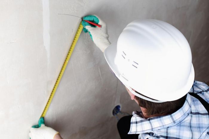 worker measuring drywall in Orange County, CA