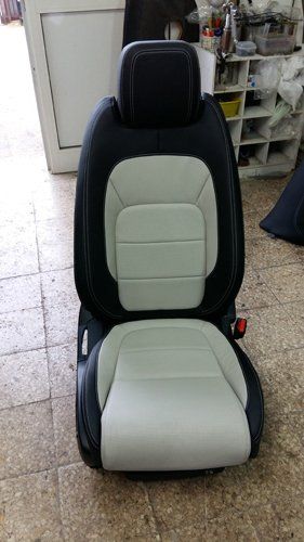 sedile nero e bianco appoggiato su un pavimento marrone e beige