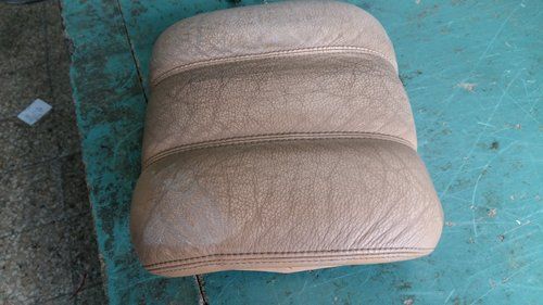 cuscino beige appoggiato su un pavimento verde acqua