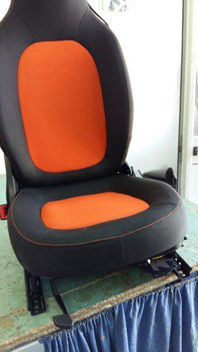 sedile da montare in un auto con tappezzeria arancione e grigia