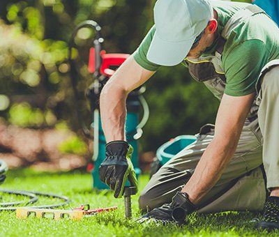 Spring Sprinkler Turn-On — Worker Installing Garden Sprinklers in Lewiston, ID Spring Sprinkler Turn-On — Worker Installing Garden Sprinklers in Lewiston, ID