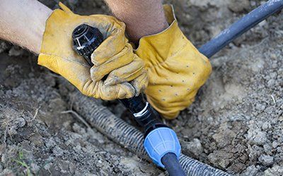 Broken Sprinkler Heads — Man Repairing an Irrigation System in Lewiston, ID