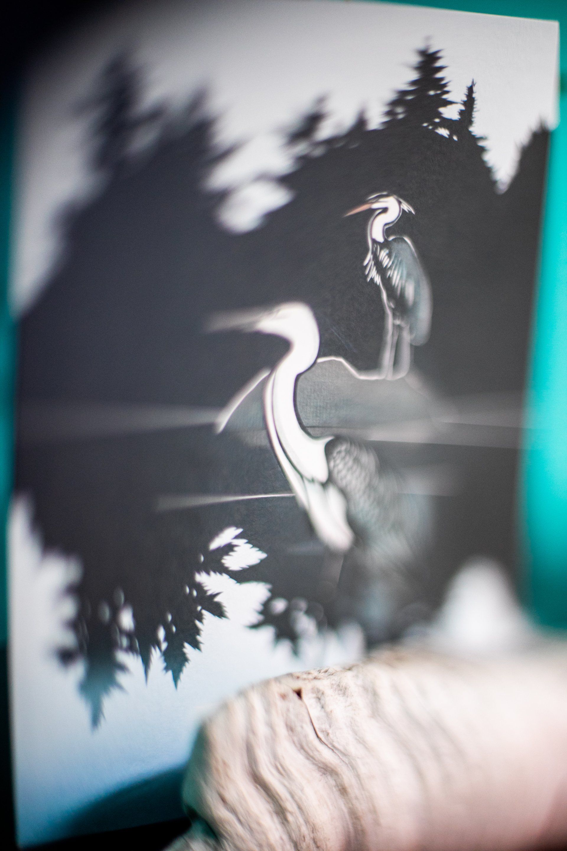 A blurry black and white painting of a Blue Heron Bird and trees