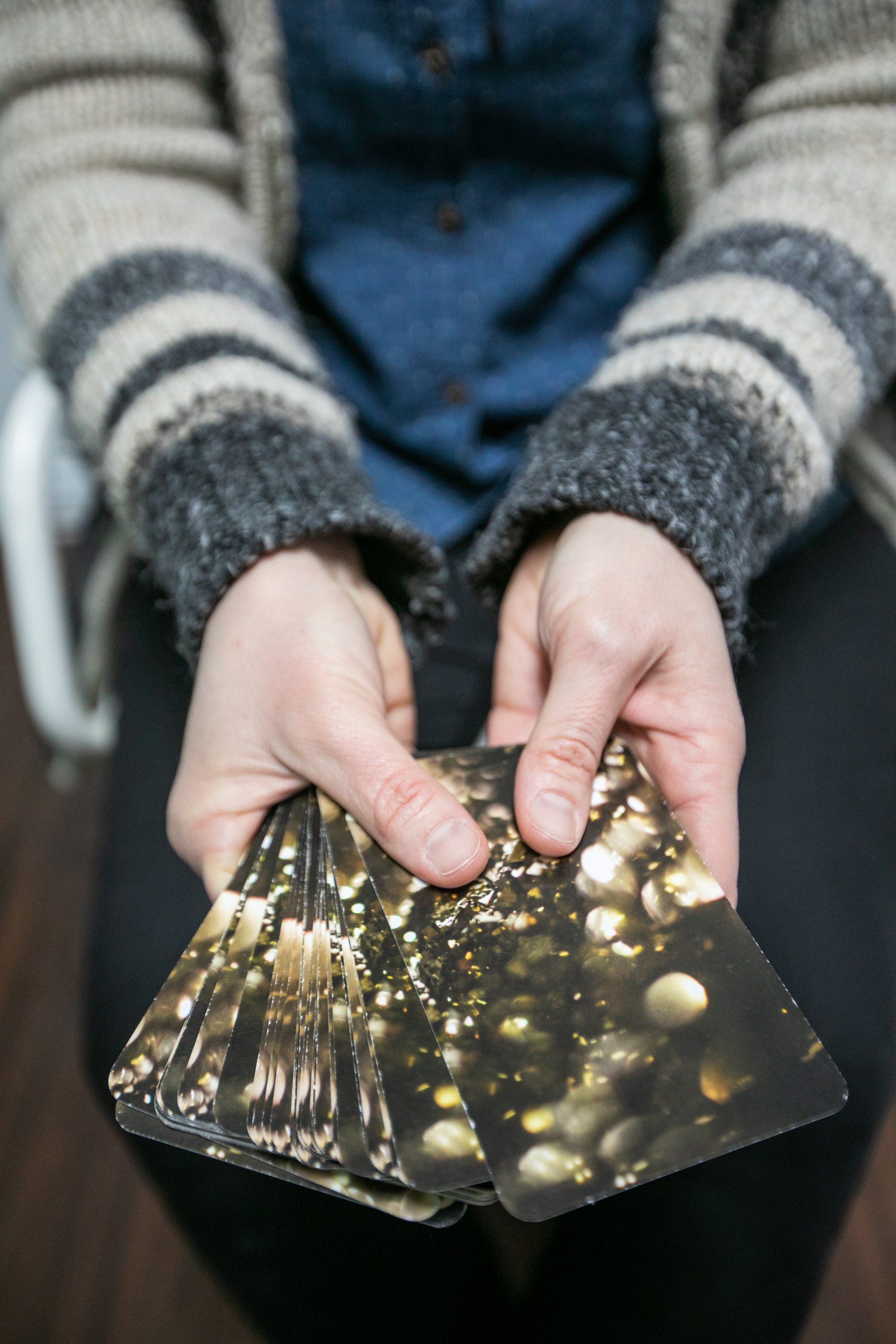 A person is holding a stack of cards in their hands.