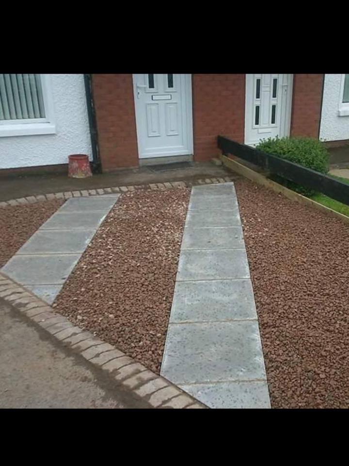 Front path with two gray stone strips and red gravel leading to a white front door