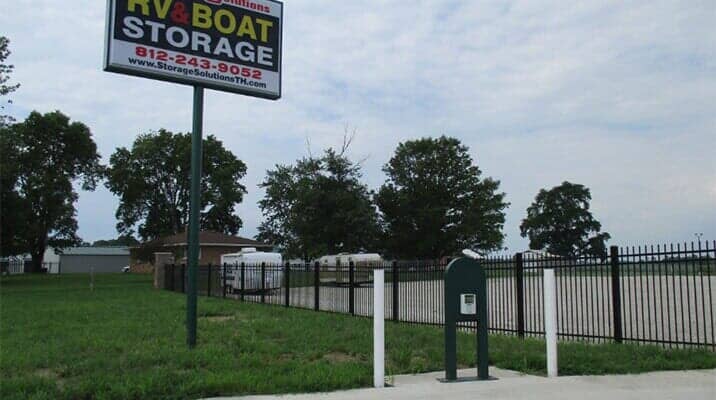 Sign for RV & Boat Storage with a gated entry, under a cloudy sky.
