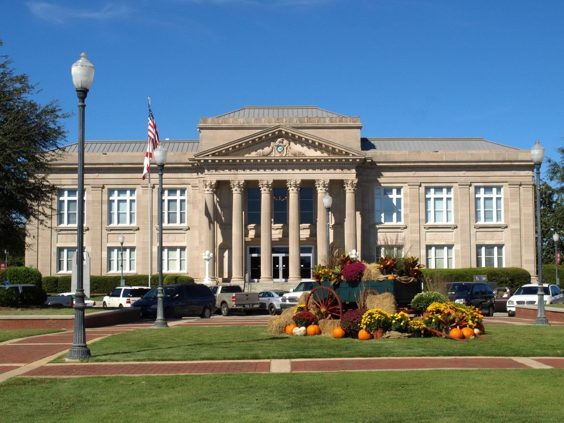 A large building with pumpkins and flowers in front of it
