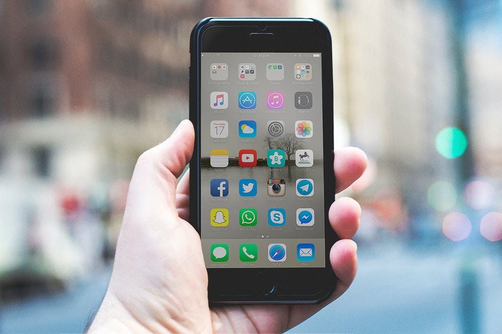 Una persona sostiene un teléfono celular en la mano.