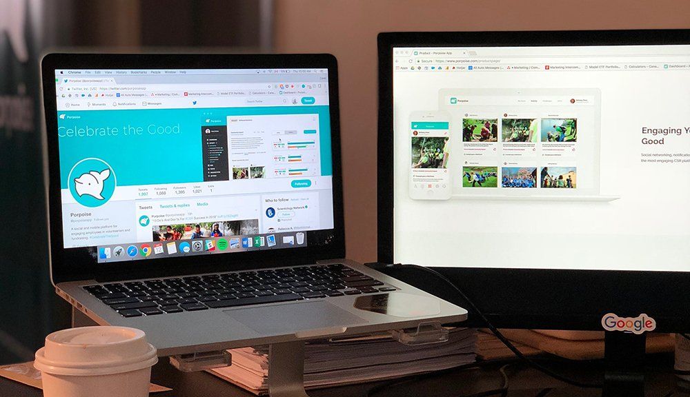 Hay una computadora portátil encima de un escritorio junto a un monitor.