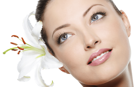 a close up of a woman 's face with a flower in her hair .