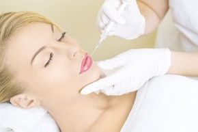 a woman is getting a botox injection in her face .