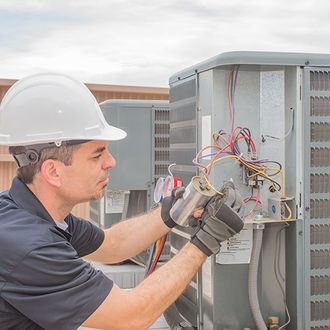 HVAC technician working on a capacitor part for condensing unit HVAC technician working on a capacitor part for condensing unit