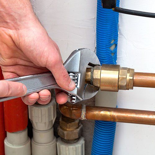 Man's hands with wrench turning off valves Man's hands with wrench turning off valves