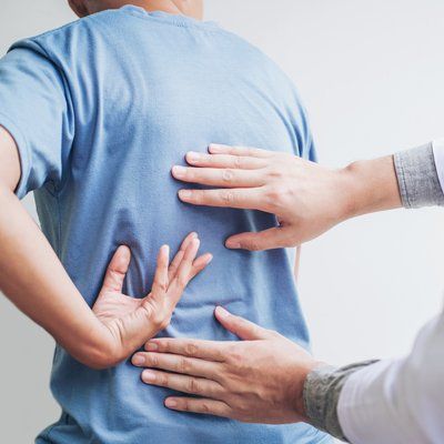 Mid Back Pain — Man And Therapist Holding in His Back In Cotuit, MA Mid Back Pain — Man And Therapist Holding in His Back In Cotuit, MA