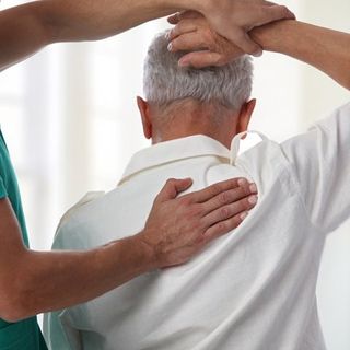Chiropractor — Chiropractor Stretching Patients Arm In Cotuit, MA