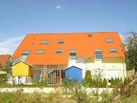 Ein Haus mit rotem Dach und blauer Garage
