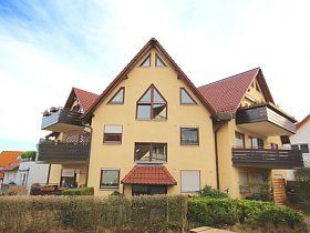 Ein großes gelbes Haus mit rotem Dach und Balkonen.