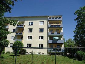Ein großes Mehrfamilienhaus mit einer Schaukel davor.