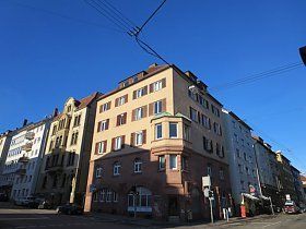 An der Ecke einer Stadtstraße steht ein großes Gebäude.