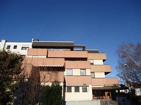 Ein großes Wohnhaus mit einem blauen Himmel im Hintergrund.