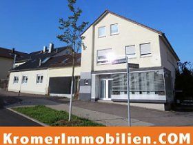 Ein großes weißes Gebäude mit einem Schild mit der Aufschrift „kromerlmmobilien.com“