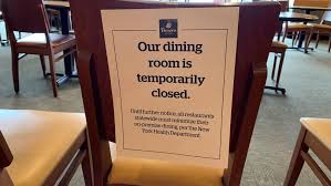 A sign on a chair in a dining room states: 