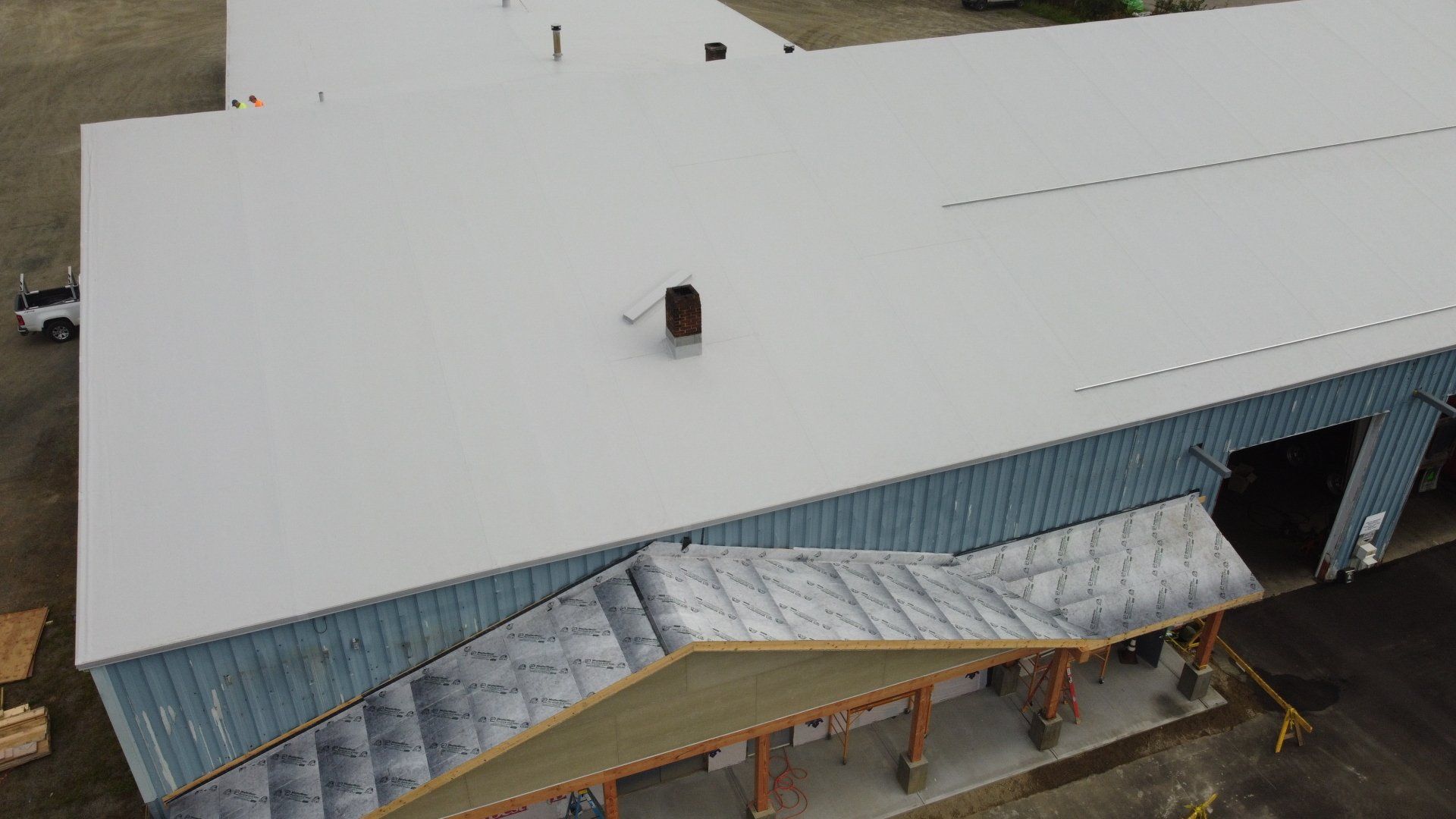 erial view of Rodd Roofing’s metal retrofit project, showcasing the contrast between new and old roofing sections
