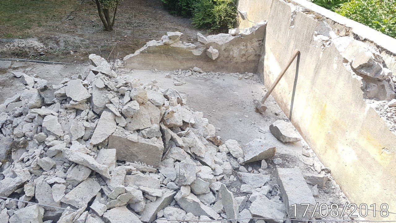 Abgerissene Betonkonstruktion mit Schutthaufen, Außenanlage.
