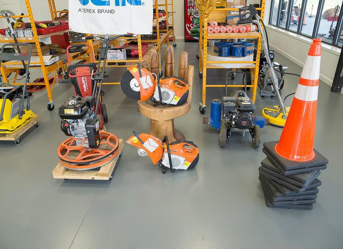 Construction equipment display inside a store with various tools on display, a traffic cone, and shelving.