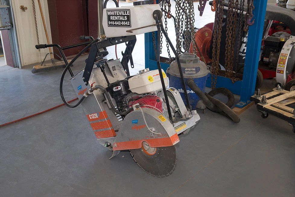 Concrete saw with a large blade in a workshop.
