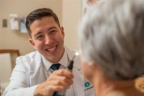 Eye doctor smiling and speaking with a patient in a clinic