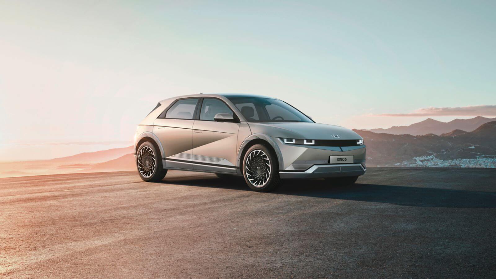 A white electric car is parked on the side of a road.  ioniq 5 