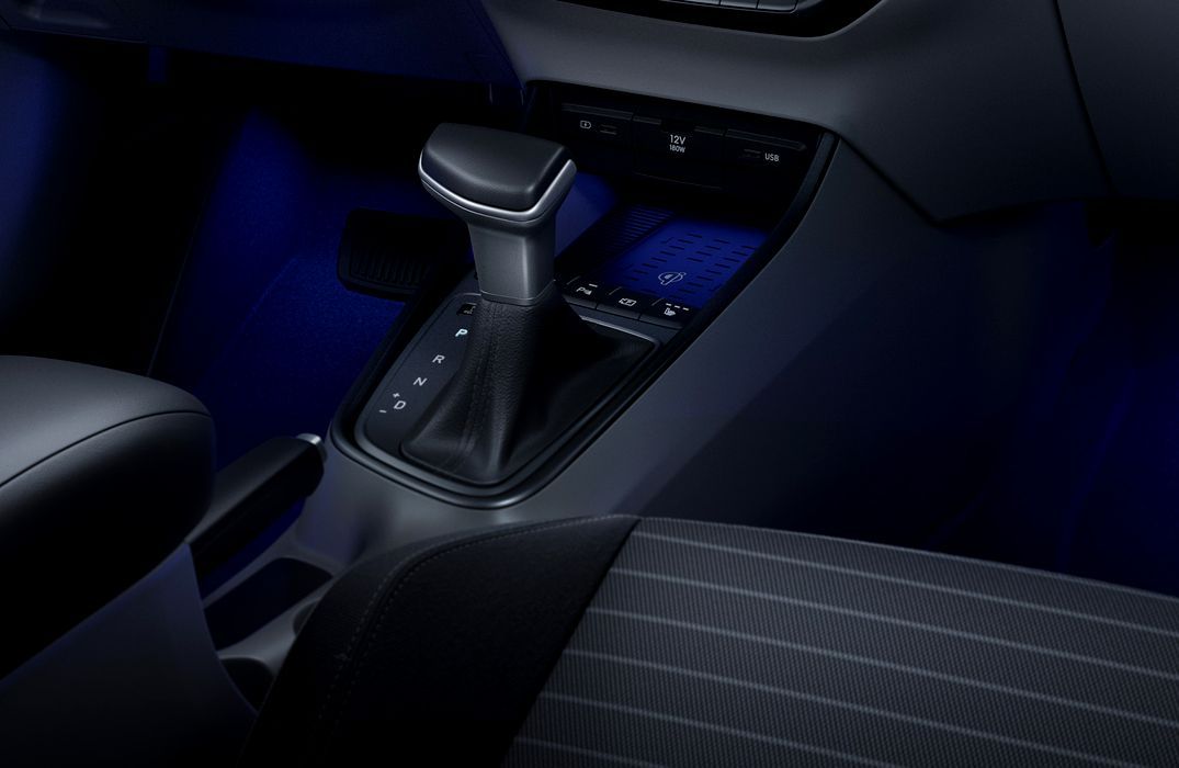 A close up of a car 's shifter with blue lights i20