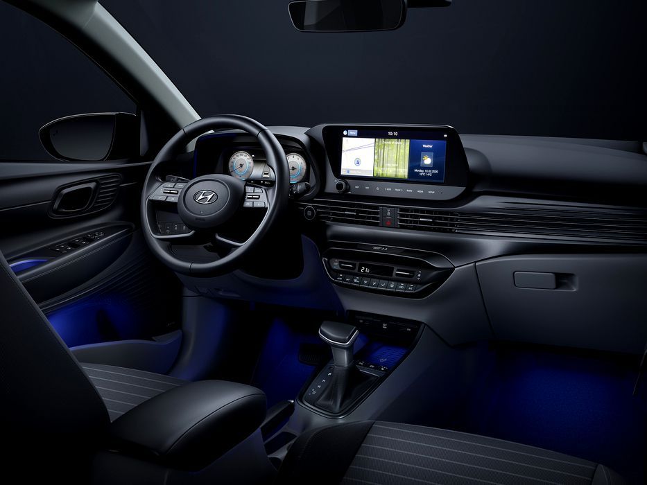 The interior of a car with a steering wheel and a dashboard. i20