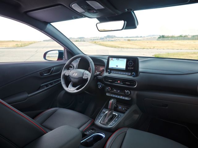 The inside of a car with a steering wheel and a radio