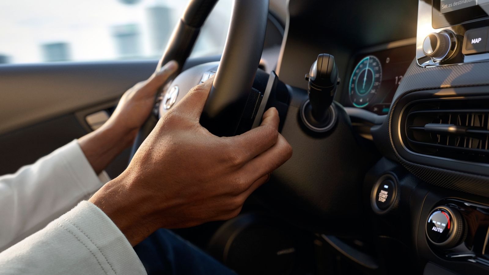 A person is driving a car with their hands on the steering wheel.