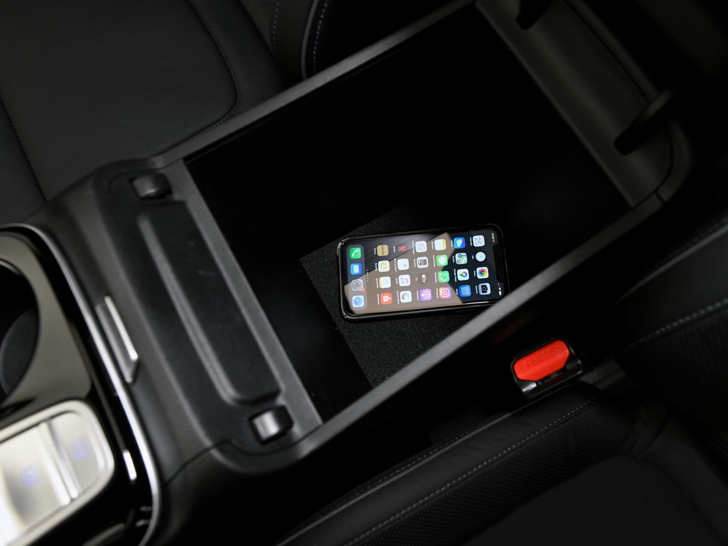 A cell phone is sitting in the center console of a car. tucson 