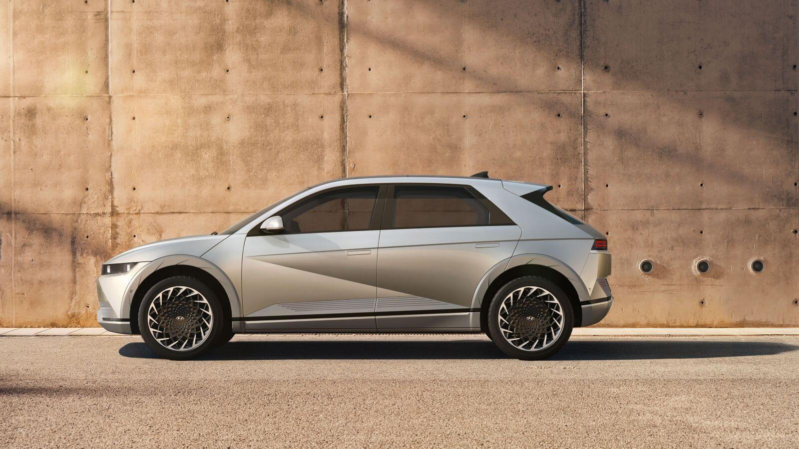 A silver car is parked in front of a concrete wall.  ioniq 5 