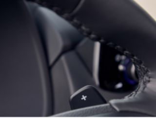 A close up of a car steering wheel with a plus sign on it