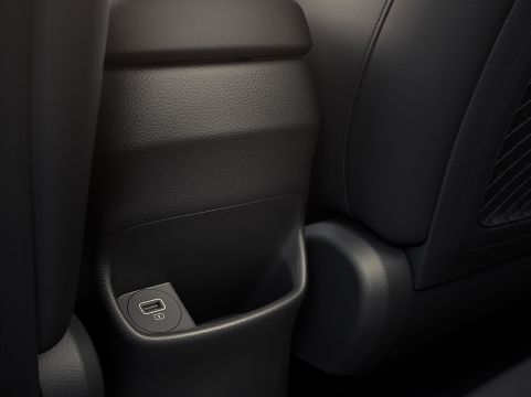 A close up of a car console with a wireless charger. Kona Hibrid