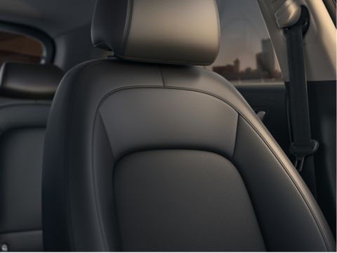 A close up of a black leather seat in a car Kona Hibrid