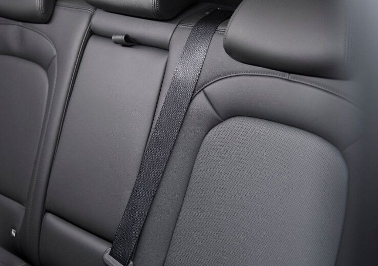 A close up of the back seat of a car with a seat belt.