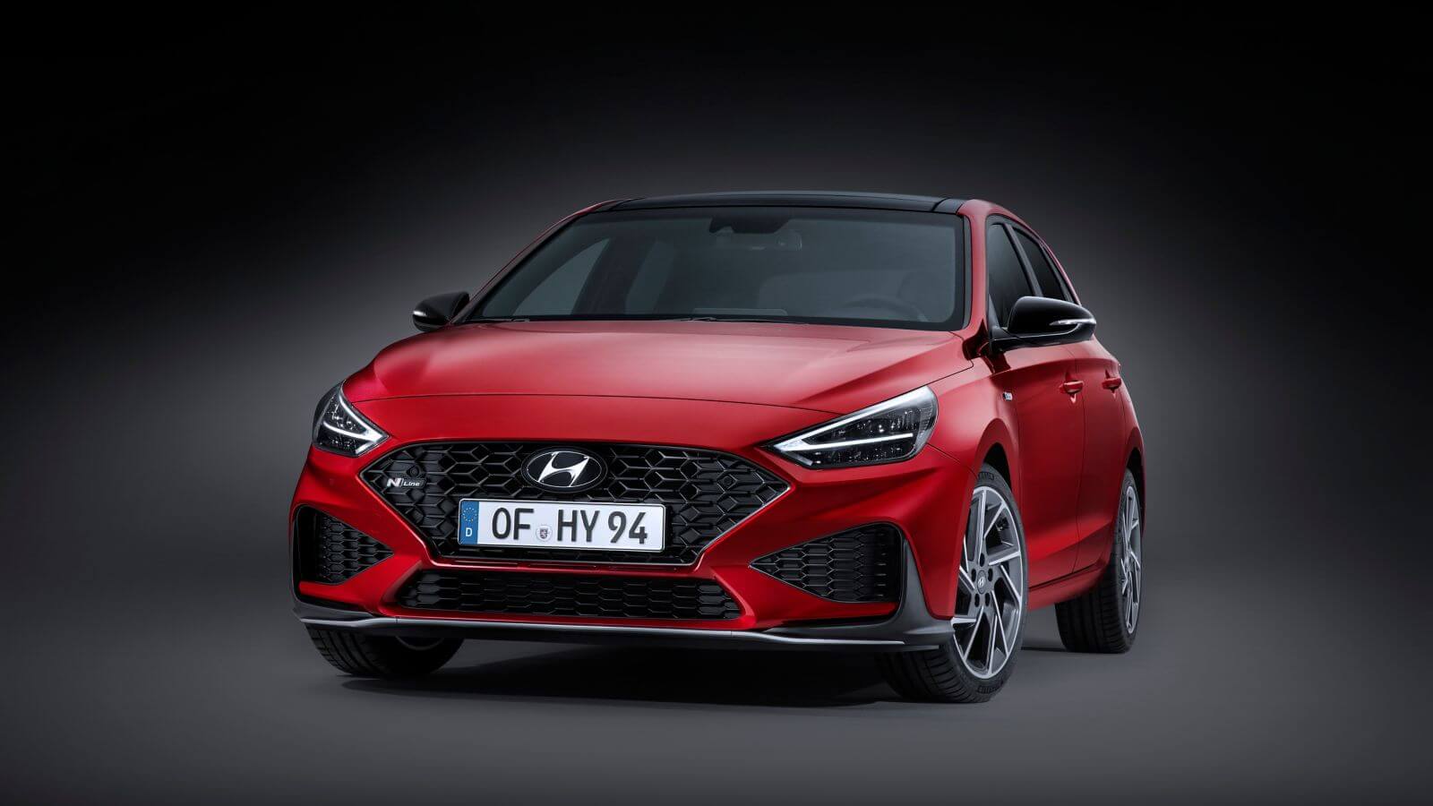 A red hyundai i30 is parked on a black background.