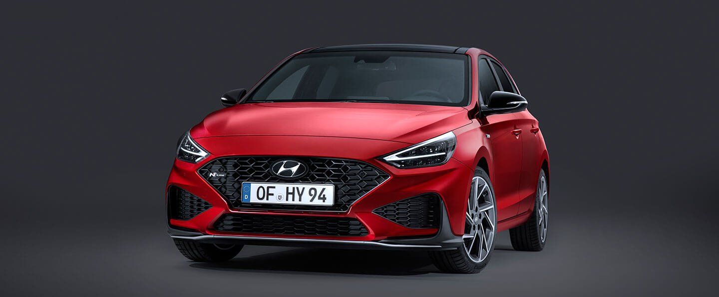 A red hyundai i30 is parked on a black background.