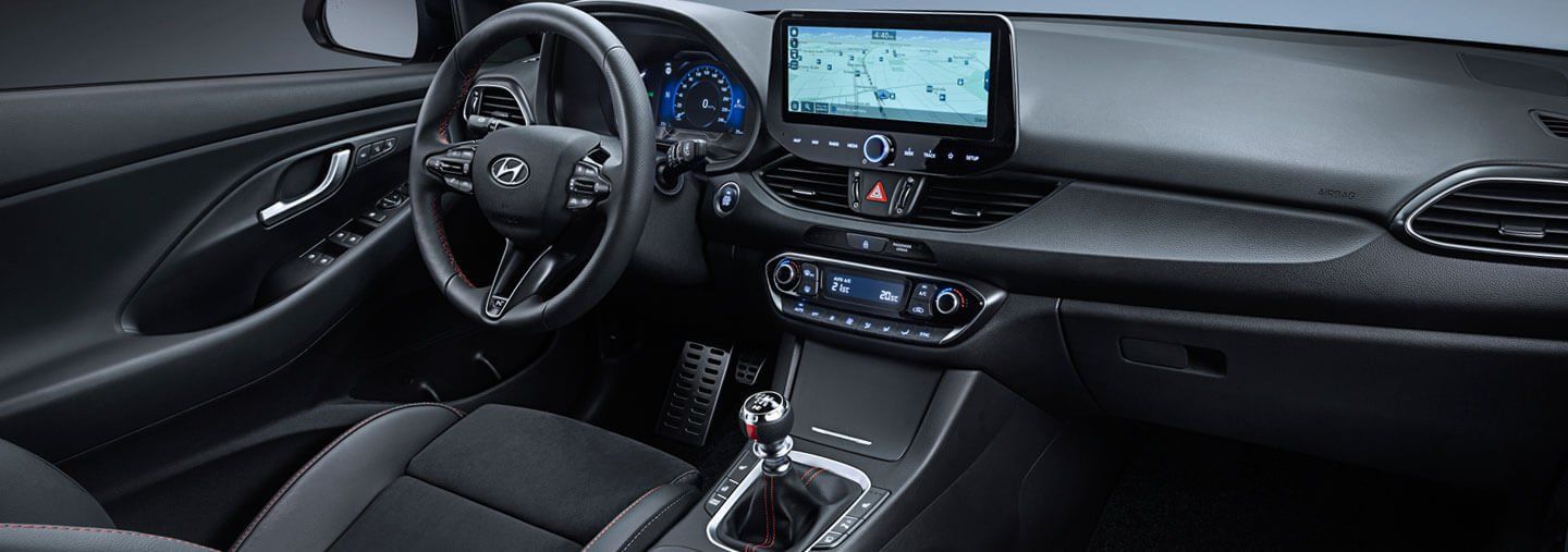 The interior of a car with a steering wheel and a dashboard.